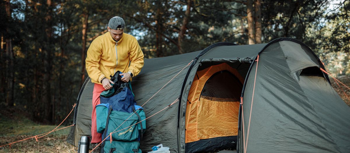 Backpacking gear laid out beside a pack at a campsite.
